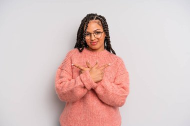 Kafası karışık, güvensiz ve şüpheyle zıt yönlere bakan siyah afro kadın.