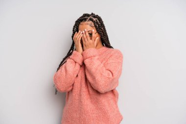 Siyah afro kadın korkmuş ya da utanmış hissediyordu. Gözleri yarı kapalı ya da elleri kapalı dikizliyordu.