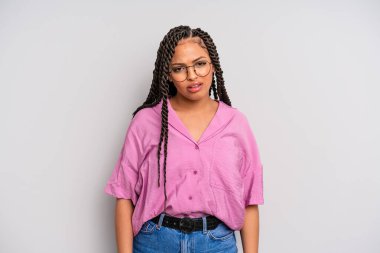 black afro woman feeling puzzled and confused, with a dumb, stunned expression looking at something unexpected