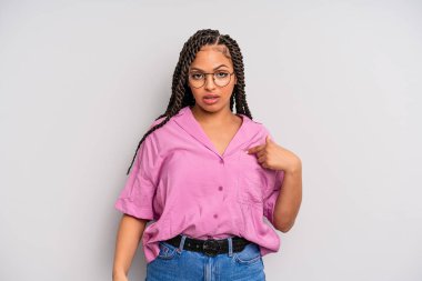 Siyah afro kadın şaşkın, şaşkın ve güvensiz hissediyor, kendini gösterip kim olduğunu soruyor, ben mi??