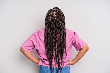 Siyah afro kadın kafası karışık ya da dolu ya da şüphe ve soru dolu, merak ediyor, elleri kalçasında, dikiz aynasından