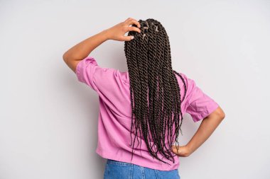 Siyah afro kadın bilgisiz ve kafası karışık, bir çözüm düşünüyor, eli kalçasında, diğeri kafasında, dikiz aynasından.