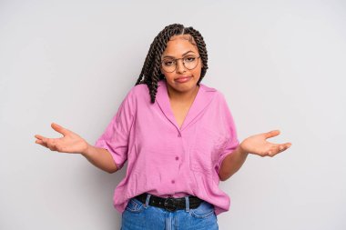 Siyah afro kadın şaşkın ve kafası karışık, doğru cevap ya da karardan emin değil, bir seçim yapmaya çalışıyor.