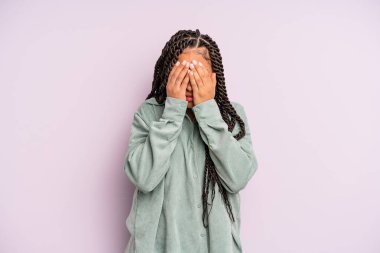 Siyah afro kadın üzgün, hayal kırıklığına uğramış, gergin ve depresif, iki eliyle yüzünü kaplayan, ağlayan