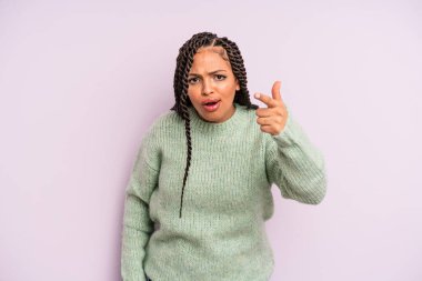 Siyah afro kadın kızgın agresif bir ifadeyle kameraya bakıyor kızgın, çılgın bir patron gibi görünüyor.