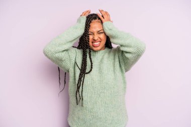 Siyah afro kadın stresli ve endişeli, depresyonda ve hayal kırıklığına uğramış, iki elini de başa kaldırıyor.