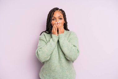 Siyah afro kadın endişeli, üzgün ve korkmuş hissediyor, elleriyle ağzını kapatıyor, endişeli ve berbat görünüyor.