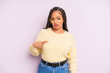 Siyah afro kadın şaşkın, şaşkın ve güvensiz hissediyor, kendini gösterip kim olduğunu soruyor, ben mi??