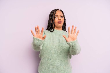 Siyah afro kadın sersemlemiş ve korkmuş hissediyor. Korkutucu bir şeyden korkuyor. Elleri açık ve uzak durun diyor.