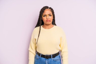 Siyah afro kadın kendini cahil, kafası karışık ve hangi seçeneği seçeceği konusunda kararsız hissediyor, sorunu çözmeye çalışıyor.