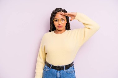 Siyah afro kadın kameraya askeri bir selamlama ile saygı göstererek, onur ve vatanseverlik eylemi yapıyor.