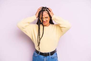 Siyah afro kadın stresli ve hayal kırıklığına uğramış hissediyor, elele tutuşuyor, yorgun, mutsuz ve migren ağrısı çekiyor.