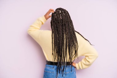 Siyah afro kadın bilgisiz ve kafası karışık, bir çözüm düşünüyor, eli kalçasında, diğeri kafasında, dikiz aynasından.