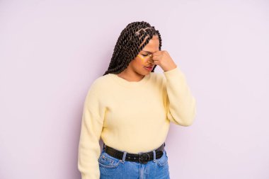 Siyah afro kadın stresli, mutsuz ve hayal kırıklığına uğramış, alınına dokunmuş ve şiddetli baş ağrısı çeken