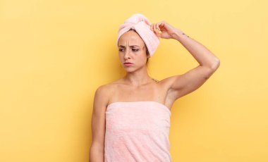 pretty woman feeling puzzled and confused, scratching head. shower and beauty concept
