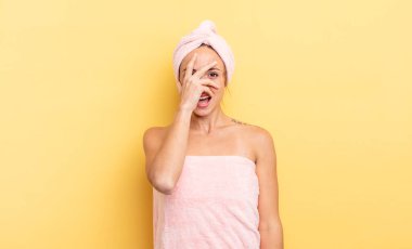 pretty woman looking shocked, scared or terrified, covering face with hand. shower and beauty concept