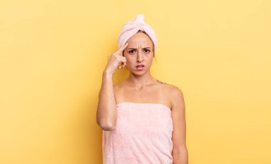 pretty woman feeling confused and puzzled, showing you are insane. shower and beauty concept