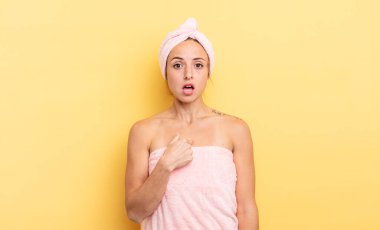 pretty woman looking shocked and surprised with mouth wide open, pointing to self. shower and beauty concept