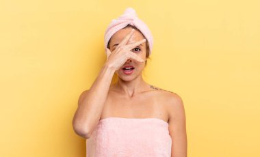 pretty woman looking shocked, scared or terrified, covering face with hand. shower and beauty concept