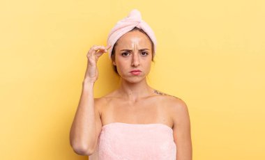 pretty woman feeling confused and puzzled, showing you are insane. shower and beauty concept