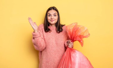 pretty woman feeling happy and astonished at something unbelievable. trash bag concept