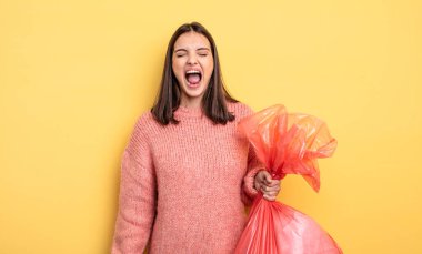 pretty woman shouting aggressively, looking very angry. trash bag concept