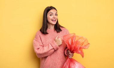 pretty woman feeling happy and facing a challenge or celebrating. trash bag concept