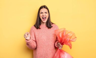 pretty woman shouting aggressively with an angry expression. trash bag concept