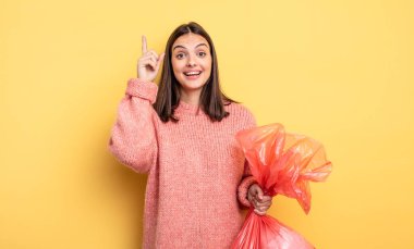 pretty woman feeling like a happy and excited genius after realizing an idea. trash bag concept