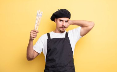 artist painter feeling stressed, anxious or scared, with hands on head