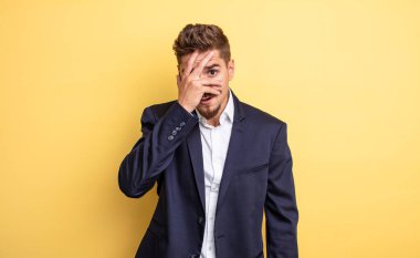 Şok olmuş, korkmuş ya da korkmuş bir iş adamı gibi görünüyor.