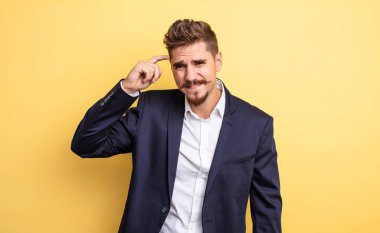 Kafası karışık ve şaşkın hisseden işadamı, deli olduğunu gösterir.