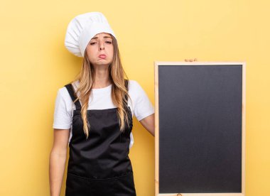 chef woman feeling sad and whiney with an unhappy look and crying. blackboard menu concept