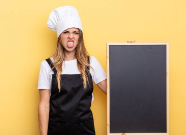 chef woman feeling disgusted and irritated and tongue out. blackboard menu concept