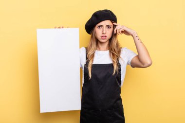 woman artist feeling confused and puzzled, showing you are insane empty canvas concept