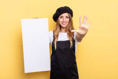 woman artist smiling and looking friendly, showing number five empty canvas concept