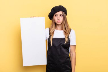 woman artist feeling sad, upset or angry and looking to the side empty canvas concept