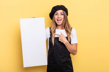 woman artist looking excited and surprised pointing to the side empty canvas concept