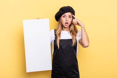 woman artist looking surprised, realizing a new thought, idea or concept empty canvas concept