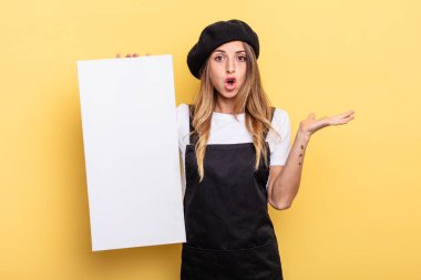 woman artist looking surprised and shocked, with jaw dropped holding an object empty canvas concept