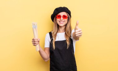 artist painter feeling proud,smiling positively with thumbs up