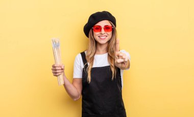 artist painter smiling proudly and confidently making number one