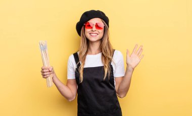 Ressam mutlu bir şekilde gülümsüyor, el sallıyor, sizi selamlıyor ve selamlıyor.