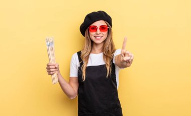 Ressam gülümsüyor ve arkadaş canlısı görünüyor.