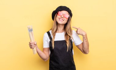 Sanatçı ressam kendine güvenerek gülümseyerek kendi gülüşünü gösteriyor.