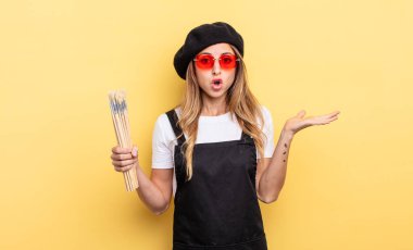 Ressam şaşırmış ve şok olmuş görünüyor, çenesi düşmüş bir nesne tutuyor.