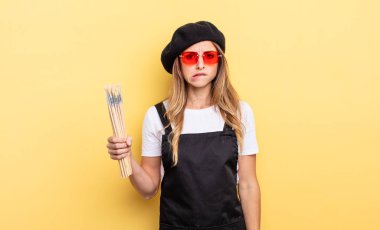 Ressam kafası karışmış ve şaşkın görünüyor.