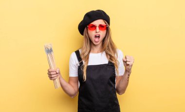 Ressam kızgın bir ifadeyle agresif bir şekilde bağırıyor.