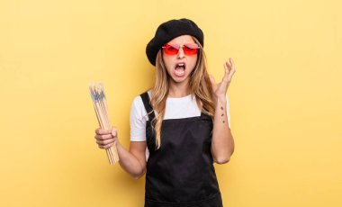 Sanatçı ressam elleri havada bağırıyor.