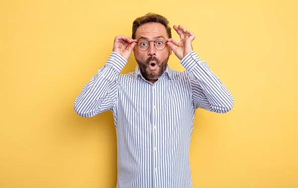 Hombre Guapo Mediana Edad Sintiéndose Sorprendido Sorprendido Sorprendido Sosteniendo Gafas — Foto de Stock
